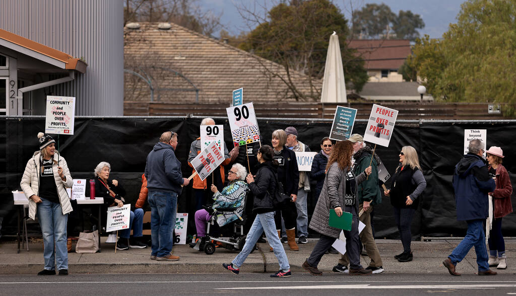 Protesters organized by Wake Up Sonoma arrayed against Ken Mattson gather in front of a fenced off property purchased by Mattson at 921 Broadway in Sonoma, Saturday, Feb. 4, 2023.   (Kent Porter / The Press Democrat) 2023