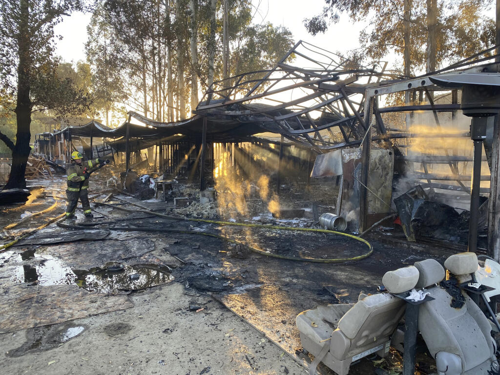 This photo provided by the City of Redlands shows the burned remains of a structure fire where firefighters discovered an illegal marijuana cultivation operation with thousands of plants in Redlands, Calif., Wednesday, Nov. 24, 2021. Authorities said they found more than 11,000 marijuana plants at an illegal growing operation after one of the buildings caught fire. Marijuana plants were found in the second building and thousands more were in a third building that wasn't damaged. Police say all of it will be destroyed. (Redlands Fire Department via AP)
