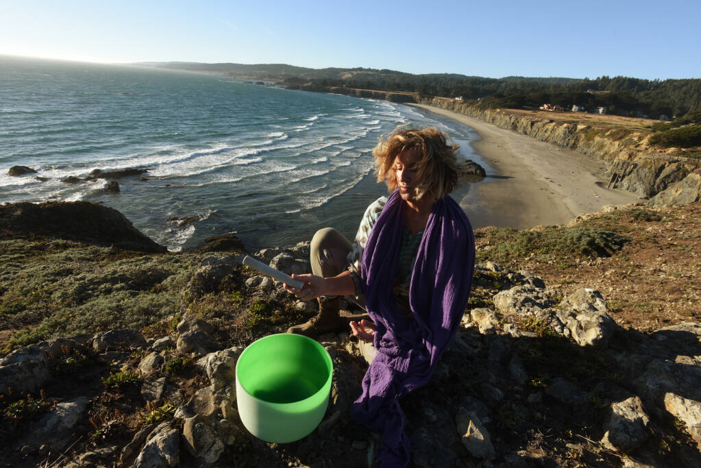 Margaret Lindgren, founder Unbeaten Path Tours using one of her crystal sound bowl at Black Point Beach in Annapolis, Calif. on Thursday, Aug. 20, 2020. (Erik Castro/For The Press Democrat)