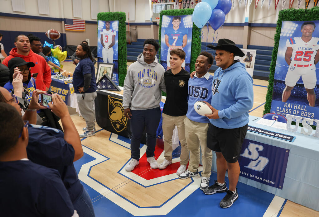 St. Vincent de Paul High School football players Nathan Rooks, left, Jaret Bosarge, Kai Hall, and Cameron Vaughn pose for photos after signing their letters of intent in Petaluma, Wednesday, Feb. 1, 2023. (Christopher Chung/The Press Democrat)