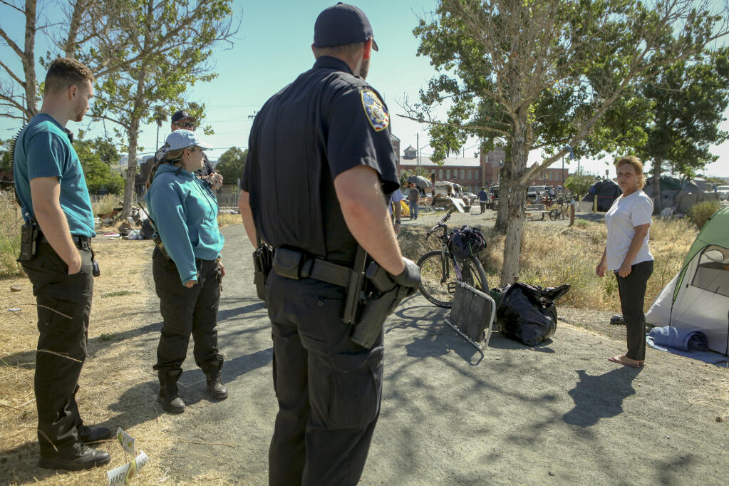 SAFE Team members (in teal shirts) worked alongside Petaluma police officers during a sweep of a homeless camp at Steamer Landing on June 13, 2022. (CRISSY PASCUAL/ARGUS-COURIER STAFF)