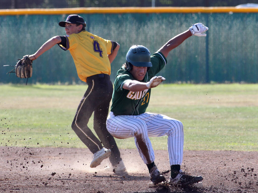 Casa Grande's Austin Steeves (27) is safe at second base stopping a possible double play as Ukiah's Caleb Ford (4) throws to first, in the 2nd inning of a North Coast Section Baseball playoff game at Casa Grande High School in Petaluma, Calif., on Wednesday, May 25, 2022. (Photo by Darryl Bush / For The Press Democrat)