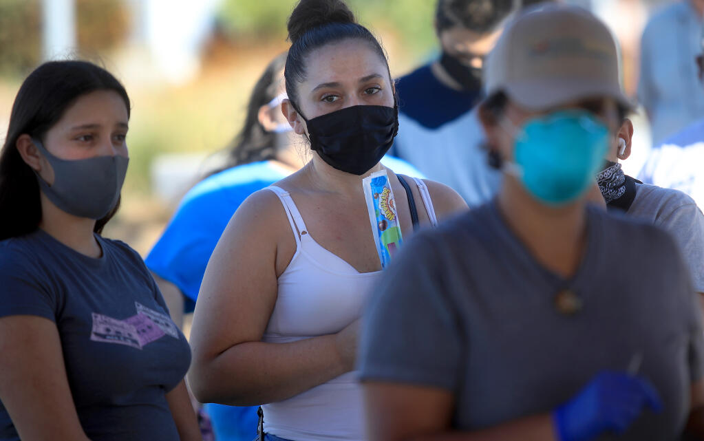 Caniella Iniguez, brought her step children Valeria Cibrian, left, and Eduardo Hurtado, obscured, right, to be swabbed for COVID-19 at Andy's Unity Park in Santa Rosa, Tuesday,  Oct. 20, 2020.  (Kent Porter / The Press Democrat) 2020