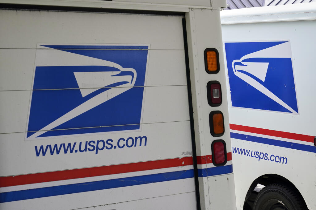 In this Aug. 18, 2020, file photo, mail delivery vehicles are parked outside a post office in Boys Town, Neb.  (AP Photo/Nati Harnik, File)