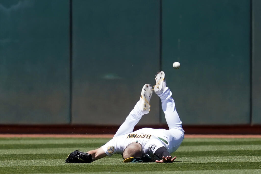 A’s left fielder Seth Brown cannot catch a triple hit by the Kansas City Royals’ Michael A. Taylor during the seventh inning in Oakland on Saturday, June 18, 2022. (Jeff Chiu / ASSOCIATED PRESS)