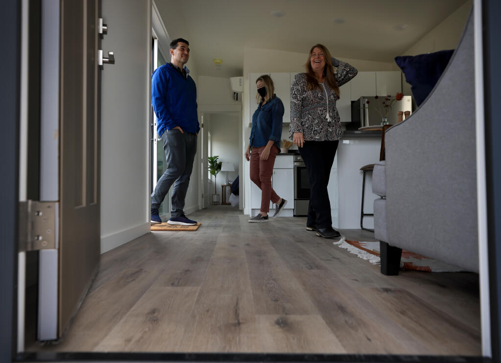 President of the board of Homes for Sonoma,  Aaron Jobson, left, and Robin Stephani, executive director, middle,  show Lisa De Carbo the interior of a home designed as an Accessory Dwelling Unit (ADU), Saturday, Nov. 6, 2021 in Santa Rosa.  (Kent Porter / The Press Democrat) 2021