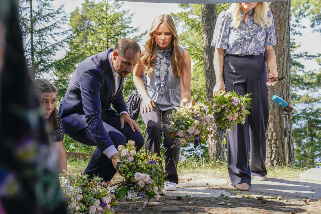 Crown Prince Hakon and Princess Ingrid Alexandra, with Crown Princess Mette-Marit obscured right, lay flowers at the July 22 memorial during the memorial service on Utoya. Commemorations to mark 10-years since Norway’s worst ever peacetime slaughter when right wing extremist Anders Breivik set off a bomb in the capital, Oslo, killing eight people, before heading to tiny Utoya island where he stalked and shot dead 69 mostly teen members of the Labor Party’s youth wing. (Torstein Boe / NTB via AP)