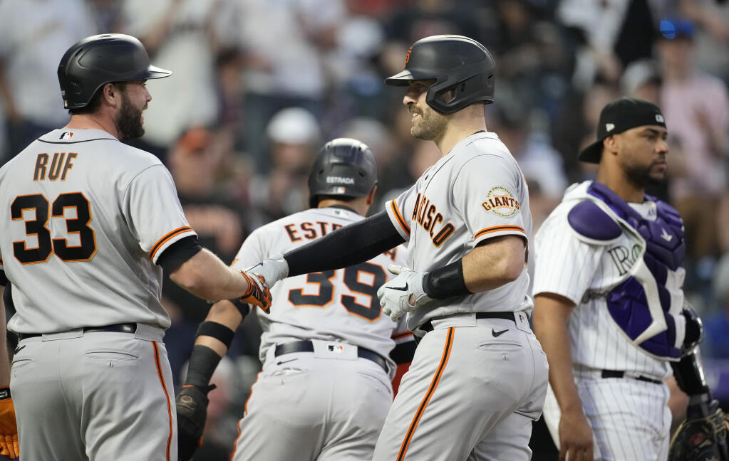 The Giants’ Darin Ruf, left, congratulates teammate Curt Casali as he crosses home plate after hitting a three-run home run off Colorado Rockies relief pitcher Ty Blach in the fifth inning Monday, May 16, 2022, in Denver. (David Zalubowski / ASSOCIATED PRESS)