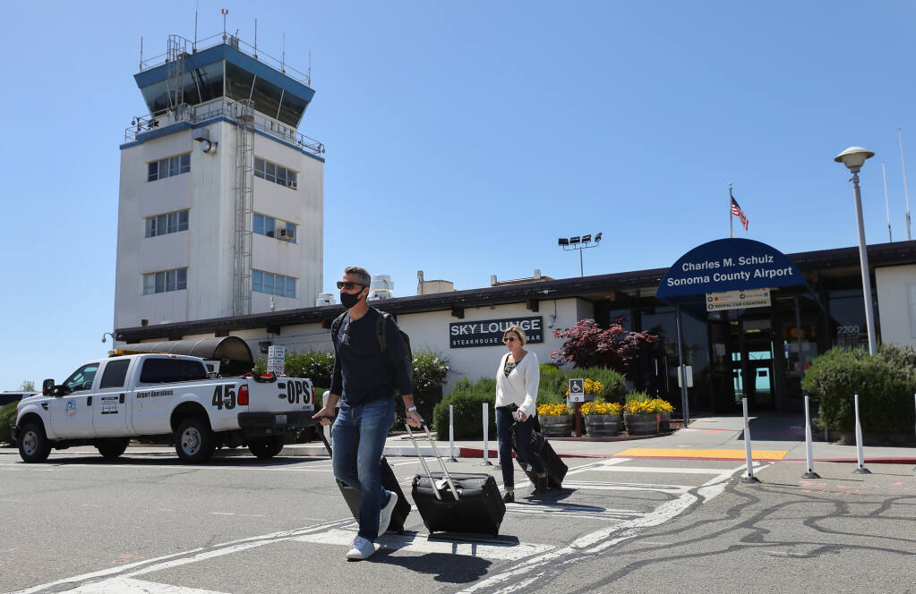 Dan and Emily Imler walk out of the Charles M. Schulz-Sonoma County Airport, after arriving from Orange County, in Santa Rosa on Thursday, April 15, 2021.  (Christopher Chung/ The Press Democrat)