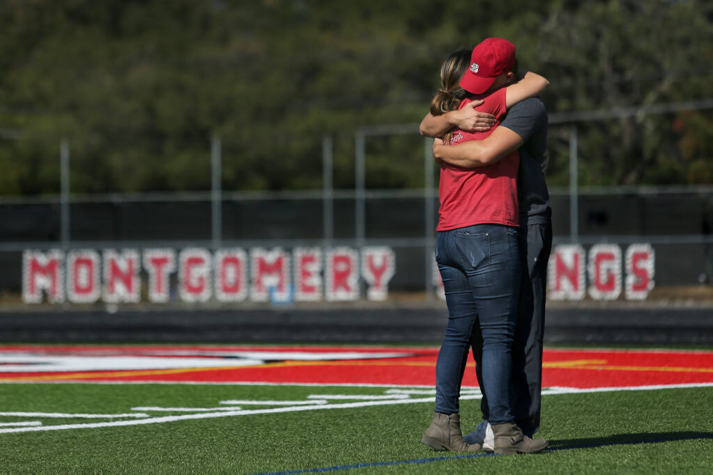 Montgomery High track and field head coach Melody Karpinski hugs former student-athlete Worthy Gutierrez who stopped by Wednesday to check in on the team after their coach Bryan Bradley, 43, died Tuesday. Photo taken at Montgomery High School in Santa Rosa, Calif., on Wednesday, August 25, 2021.(Beth Schlanker/The Press Democrat)