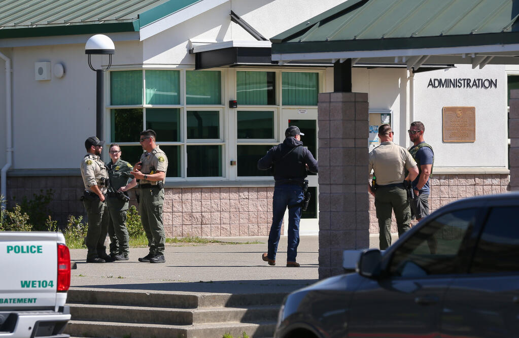 Sonoma County Sheriff’s personnel and Windsor Police gather at the entrance of Windsor Middle School during a lockdown in Windsor on Friday, April 14, 2023.  (Christopher Chung/The Press Democrat)