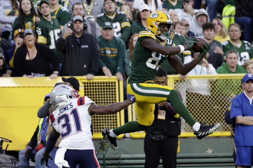 Green Bay Packers wide receiver Romeo Doubs (87) catches a 13-yard touchdown pass over New England Patriots cornerback Jonathan Jones (31) during the second half of an NFL football game, Sunday, Oct. 2, 2022, in Green Bay, Wis. (AP Photo/Matt Ludtke)