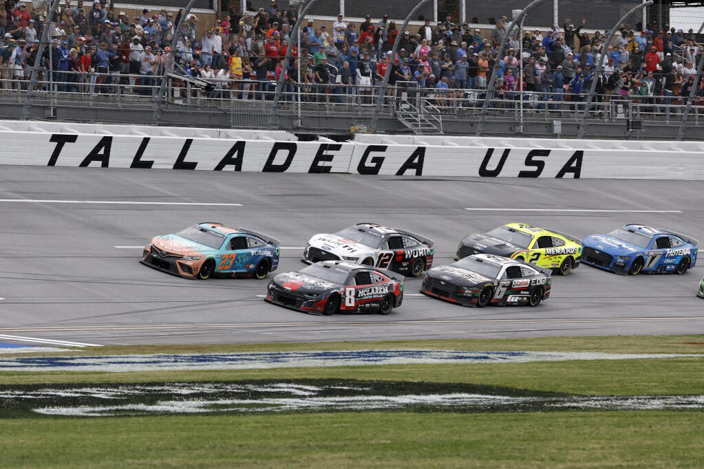 Bubba Wallace (23) and Kyle Busch (8) lead the pack to the restart in the second overtime during a NASCAR Cup Series auto race at Talladega Superspeedway, Sunday, April 23, 2023, in Talladega, Ala. (AP Photo/Butch Dill)