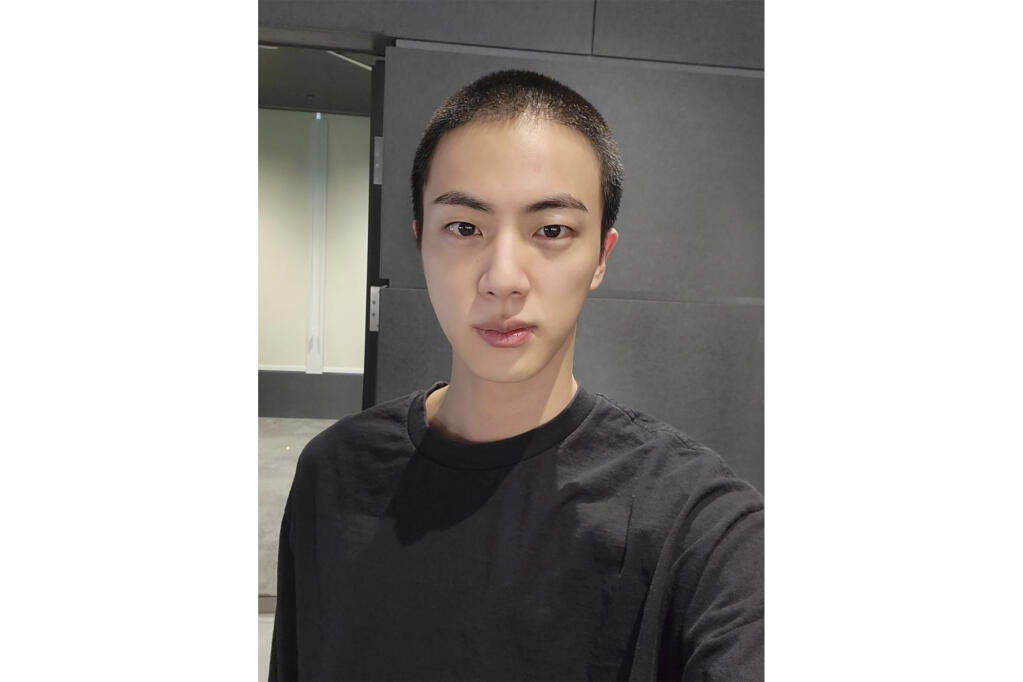In this photo provided by Weverse, Jin of K-pop band BTS shows off freshly shaved hair on the K-pop social media platform Weverse, which was uploaded Sunday, Dec. 11, 2022, ahead of his upcoming military conscription. Jin, the oldest member of K-pop supergroup BTS, was set to enter a frontline South Korean boot camp Tuesday to start his 18 months of mandatory military service, as fans gathered near the base to say goodbye to their star. (Weverse via AP)
