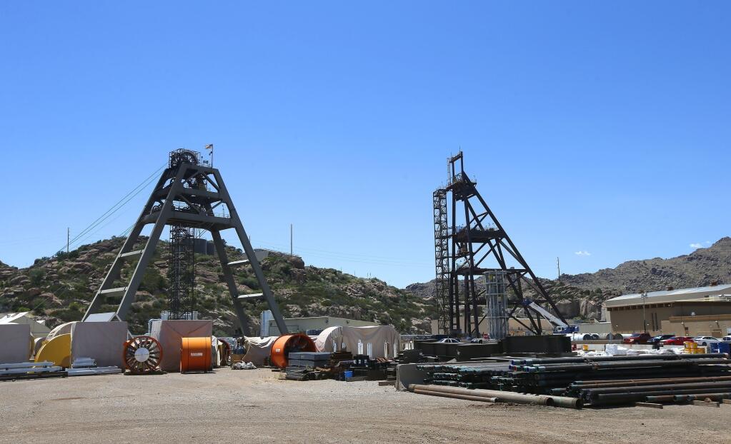 FILE - Equipment stands around the Resolution Copper Mining area Shaft #9, right, and Shaft #10, left, that awaits the expansion go ahead in Superior, Ariz.,  June 15, 2015. A mine like it could help address climate change by helping the United States replace fossil fuels and combustion engines with renewable energy and electric cars. But to Nosie, a former chairman of the San Carlos Apache Tribe, it’s the latest insult in a bitter history. The tribe considers the rolling hills and hidden canyons under which the copper lies — an area of Arizona called Oak Flat — to be a corridor to God inhabited by holy spirits. The tribe’s reservation is roughly 35 miles away. (AP Photo/Ross D. Franklin, File)