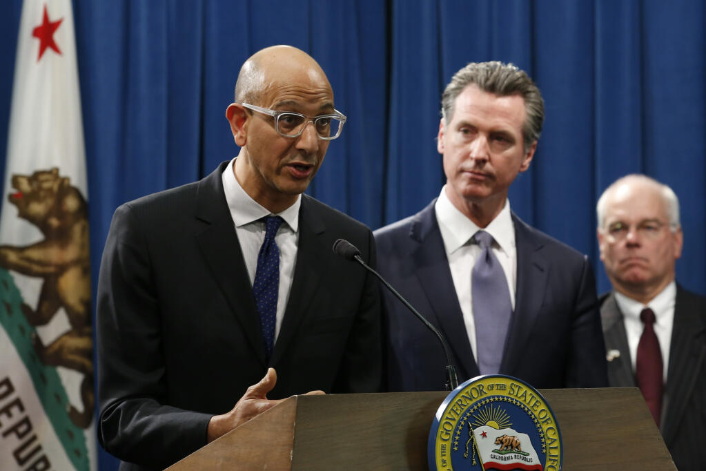 Dr. Mark Ghaly, secretary of California Health and Human Services, discusses the coronavirus as Gov. Gavin Newsom, center, listens at a news conference in Sacramento on March 12, 2020. Ghaly confirmed Friday that Sonoma, Mendocino and 11 other counties statewide are now eligible to resume more business and public activities.  (Rich Pedroncelli / Associated Press)