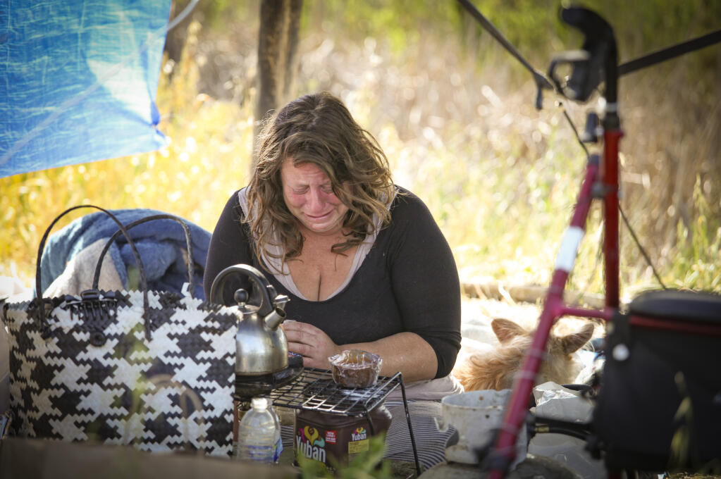 The Petaluma Police Department swept a homeless encampment near Steamer Landing Park on Friday, April 30, 2021. Worrying about where they will go next, Sarah Gossage cries in the tent she and her boyfriend, Mark van derVen, set up next to the Petaluma River. She was upset because she thought she would be given more notice of the sweep because she said she has a plan to move and get a job soon. (CRISSY PASCUAL/ARGUS-COURIER STAFF)