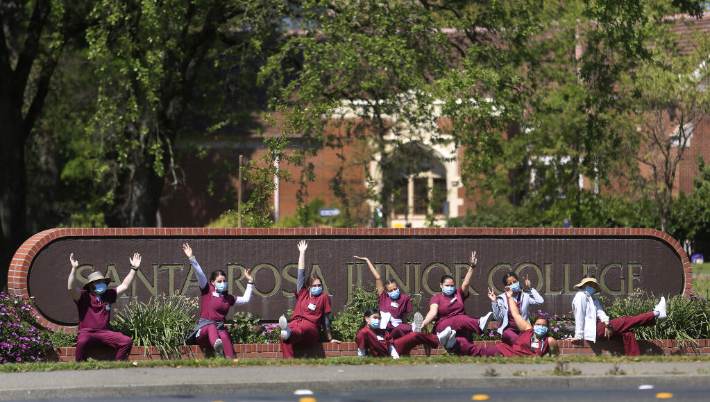 A class of Certified Nursing Assistants have their photograph made by their instructor, Tuesday, April 13, 2021 in front of Santa Rosa Junior College in Santa Rosa.  The CNA students are on a hybrid schedule, with campus instruction and remote learning.  (Kent Porter / The Press Democrat) 2021