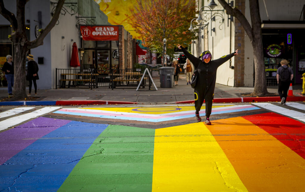 Asher Brenner shows her excitement to see the newly painted rainbow flag on the crosswalk of Kentucky Street in downtown Petaluma last week as she was on her way to work on Friday, Oct. 28, 2022. (CRISSY PASCUAL/ARGUS-COURIER STAFF)