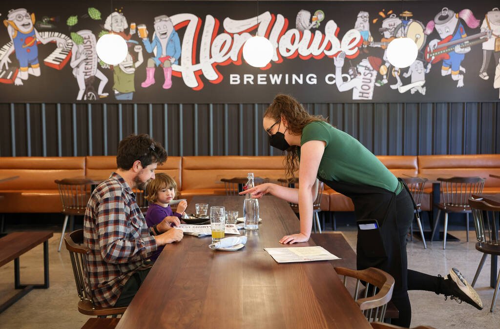 Server Yasmin Prenctice, right, helps Colin Kelly and his three-year-old daughter, Story, with their order at the new HenHouse Brewing Company West County Pub location in Fairfax on Wednesday, April 27, 2022. (Christopher Chung/The Press Democrat)