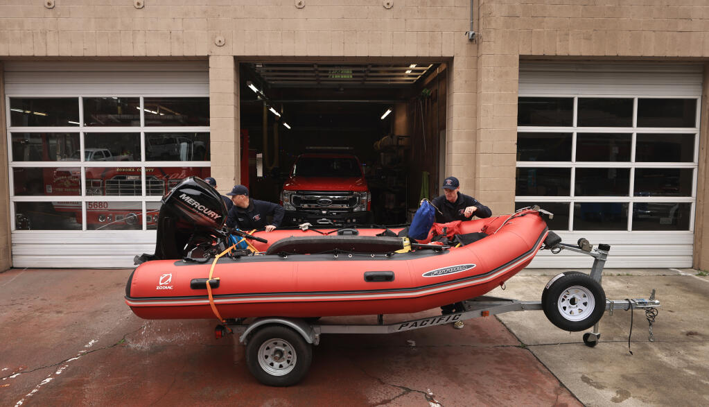 From left, Mike Franceschi, Jason Dooyes and Ryan Vincent with Sonoma County Fire District’s Guerneville station, perform pre-flood checks on the department’s swift water rescue zodiac, Tuesday, Jan. 3, 2023. (Kent Porter/The Press Democrat)