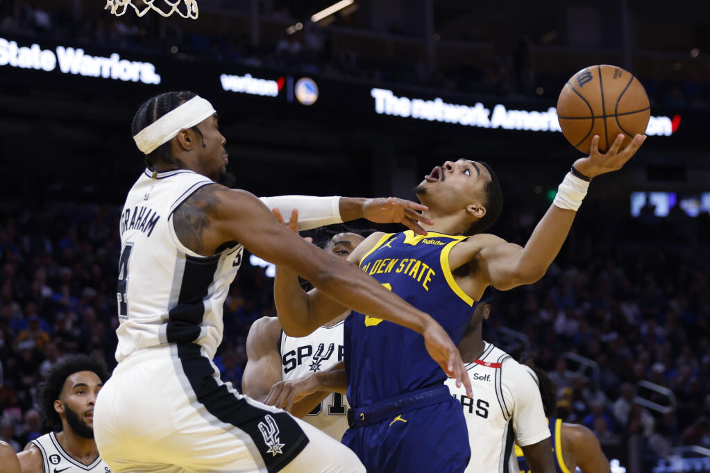 Golden State Warriors guard Jordan Poole, right, shoots against San Antonio Spurs guard Devonte’ Graham, left, during the second half in San Francisco, Friday, March 31, 2023. (Jed Jacobsohn / ASSOCIATED PRESS)