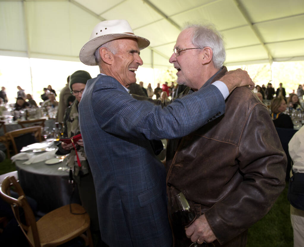 Tom Klein of Rodney Strong Vineyards, the honoree for Lifetime Achievement award at this year’s auction, hugs his pal, David Ramey of Ramey Wine Cellars, right, during the annual Sonoma County Barrel Auction at MacMurray Ranch, Friday, May 5, 2023, in Healdsburg. (Darryl Bush / For The Press Democrat)