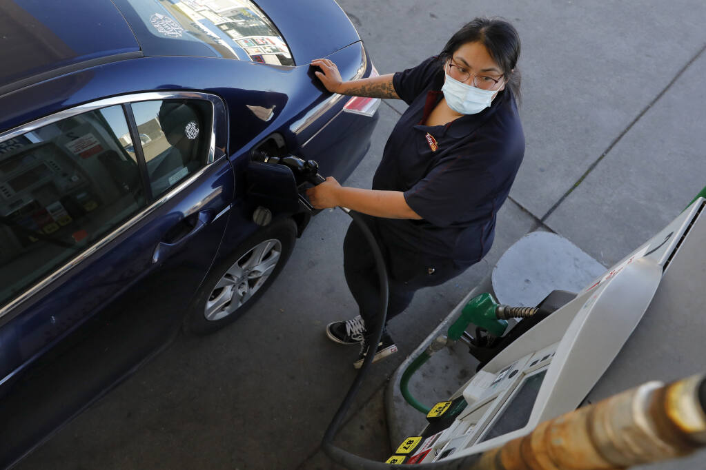 Laura Sanchez watches the pump as she fills her car up with gas at the Roseland Gas Mart in Santa Rosa, Calif., Nov. 3, 2021. The state's highest recorded average price last recorded was in November. (Beth Schlanker/The Press Democrat)