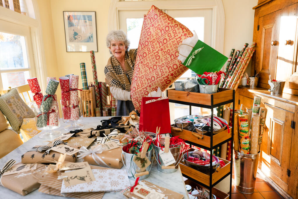 Kathleen Ferrington with some of the items she sets out for guests at Christmas “It's a Wrap” party at Santa Rosa home.(John Burgess/The Press Democrat)