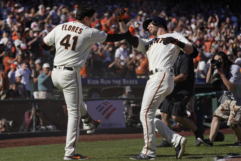San Francisco Giants' Wilmer Flores (41) celebrates with Austin Slater after hitting a two-run home run that scored Bryce Johnson during the ninth inning of a baseball game in San Francisco, Sunday, Sept. 4, 2022. (AP Photo/Jeff Chiu)