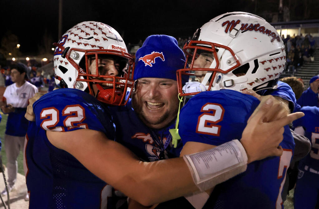 St. Vincent head coach Trent Herzog celebrates with Jake DeCarli, left, and Dante Antonini after the Mustangs took the NCS Division 7 title against St. Helena on Saturday, Nov. 27, 2021 at Petaluma High School. (Kent Porter / The Press Democrat)