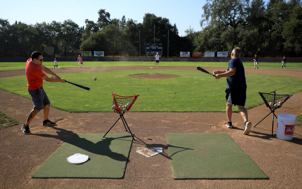 With the entire infield appropriately distanced, coaches Cesar Navarro, left,  and Michael Wooley take their Majors team through an infield drill, Monday, August 10, 2020 at the Santa Rosa American Little League fields behind Monroe Elementary. (Kent Porter / The Press Democrat) 2020