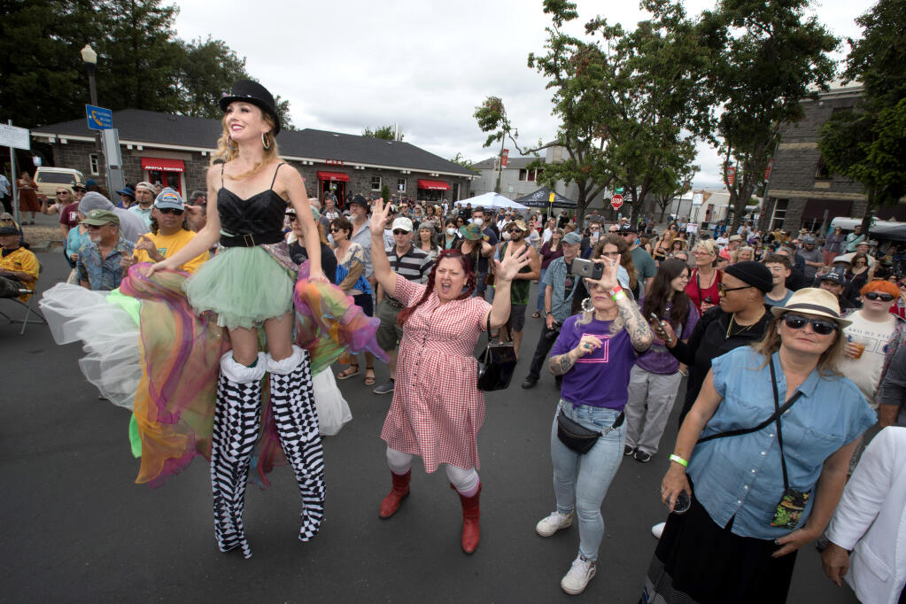 People watch the band, Erica Ambrin and the Eclectic Soul Project perform, including, Krysta Cook, of Santa Rosa, left on stilts, at the Railroad Square Music Festival, Sunday, June 12, 2022, in Santa Rosa. (Darryl Bush / For The Press Democrat)