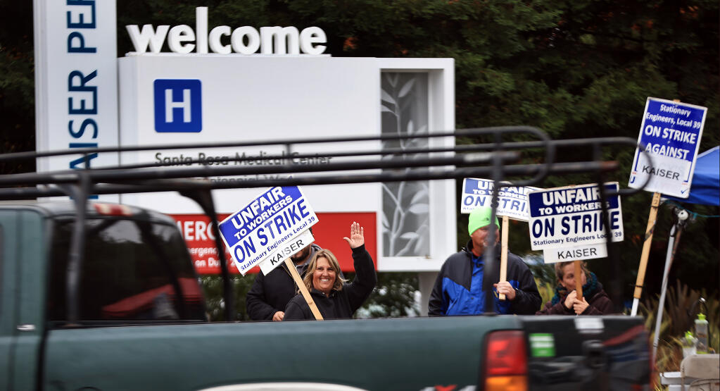 Kaiser engineer Debbie Clay reacts to a driver who honked in support of the engineers strike in front of Kaiser Permanente, Wednesday, October 20, 2021 at the corner of Mendocino Ave. and Bicentennial Way in Santa Rosa. (Kent Porter / The Press Democrat) 2021