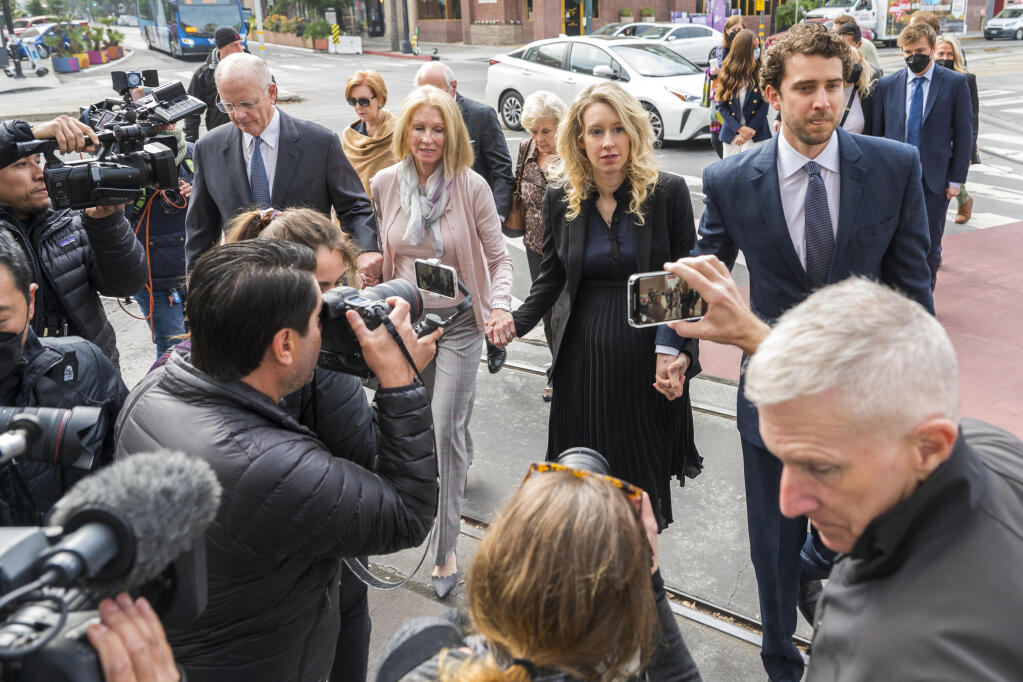 Theranos founder and CEO Elizabeth Holmes, center, walks into federal court with her partner Billy Evans, right, and her parents in San Jose, Calif., Friday, Nov. 18, 2022. (AP Photo/Nic Coury)