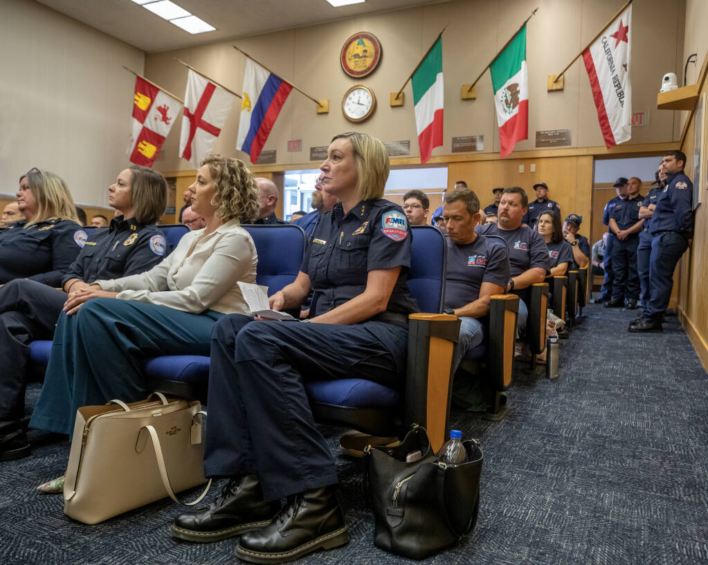 American Medical Response’s K.T. McNulty, center, sits in the front row before speaking to the Sonoma County Board of Supervisors, Tuesday, June 6, 2023, in Santa Rosa. Fire personnel lined the chambers during public comment at a hearing to award a new contract for emergency medical services in Sonoma County. (Chad Surmick / The Press Democrat)