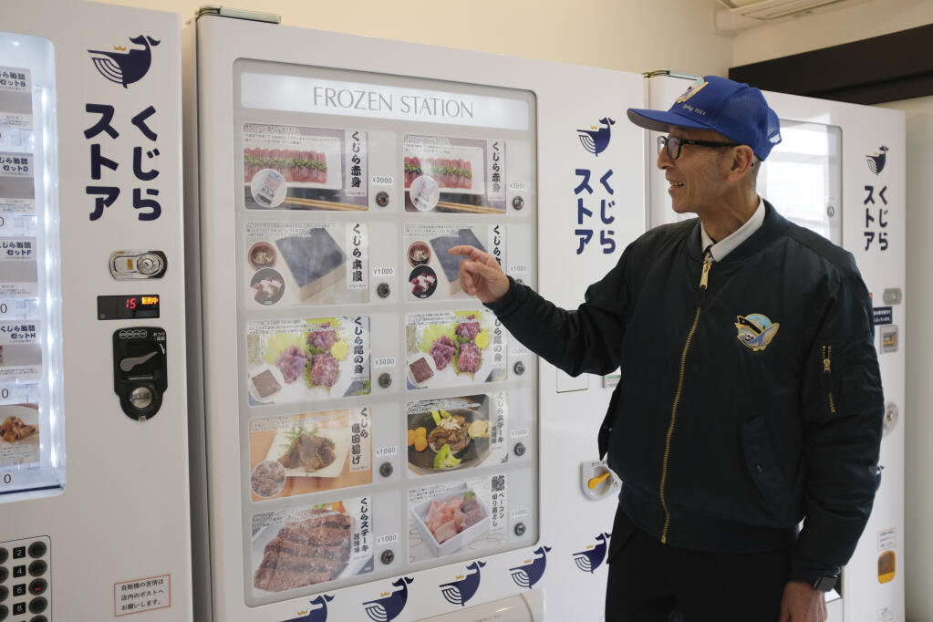 Konomu Kubo, a spokesperson for Kyodo Senpaku Co. explains how whale meat is being sold from a vending machine at the firm's store, Thursday, Jan. 26, 2023, in Yokohama, Japan. The Japanese whaling operator, after struggling for years to promote its controversial products, has found a new way to cultivate clientele and bolster sales: whale meat vending machines. (AP Photo/Kwiyeon Ha)