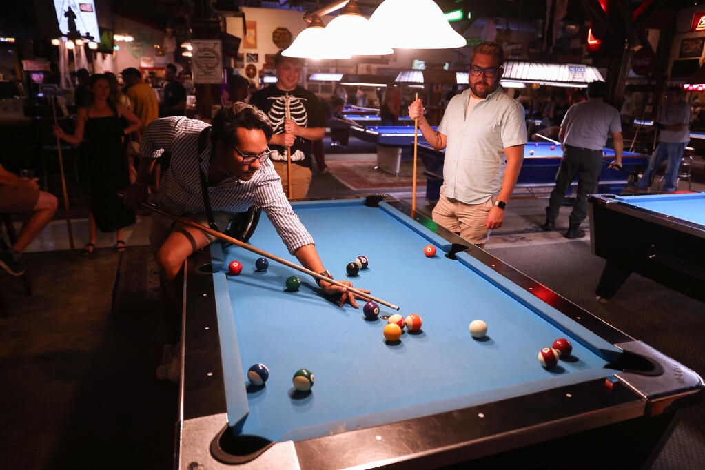 Kevin Rojas, left, plays a round of pool with Donnie Mackenzie and Joey Zappelli during Petaluma Pride’s Pride Night  at Buffalo Billiards in Petaluma, Thursday, Oct, 5, 2023. (Christopher Chung / The Press Democrat)