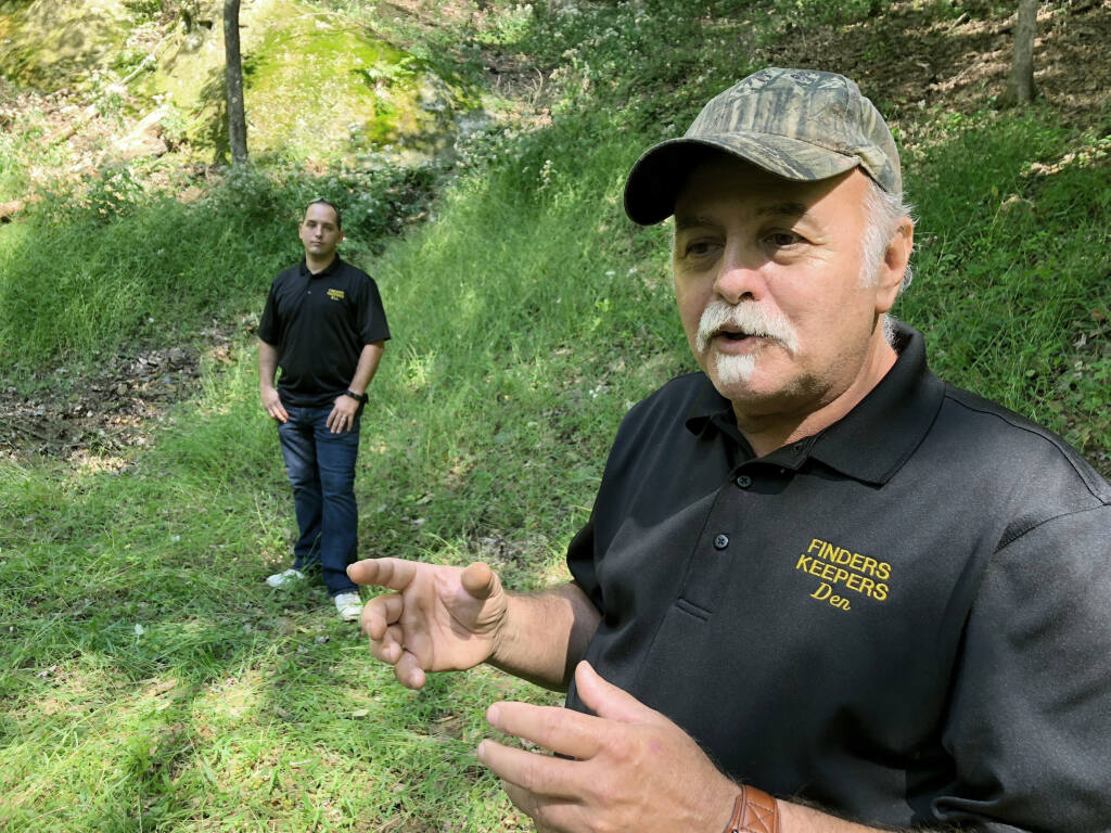 FILE - Dennis Parada, right, and his son Kem Parada stand at the site of the FBI's dig for Civil War-era gold in Sept, 2018, in Dents Run, Pennsylvania. A scientific report commissioned by the FBI shortly before agents went digging for buried treasure suggested that a huge quantity of gold was below the surface, according to newly released government documents. (AP Photo/Michael Rubinkam, File)
