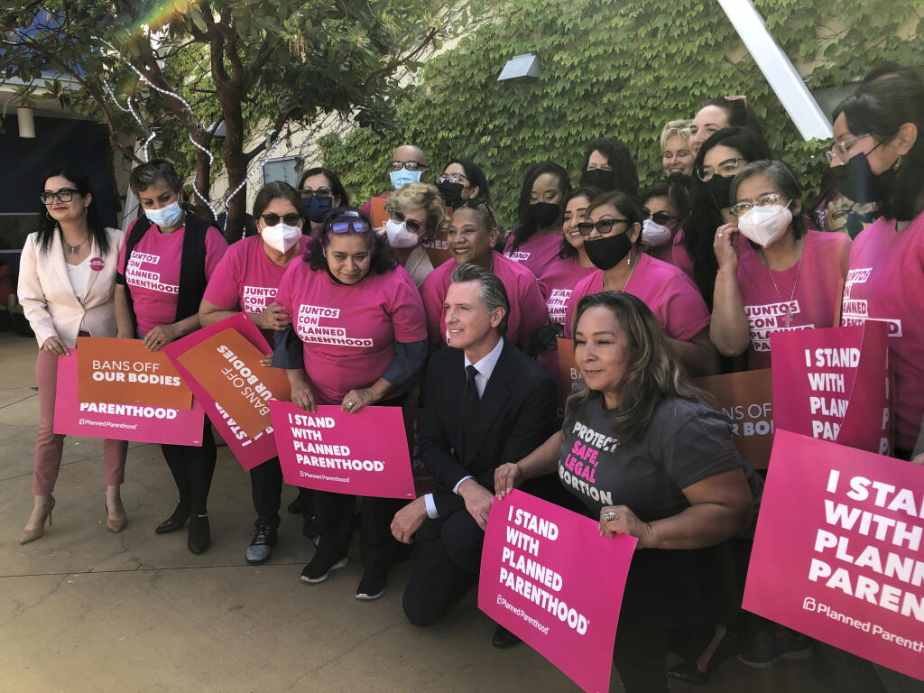 California Gov. Gavin Newsom poses with workers and volunteers on Wednesday, May 4, 2022, at a Planned Parenthood office near downtown Los Angeles. Newsom faulted his own political party Wednesday for setbacks in the nation's culture wars and urged Democrats to launch a vocal “counter-offensive” to protect rights from abortion to same-sex marriage. (AP Photo/Michael R. Blood)