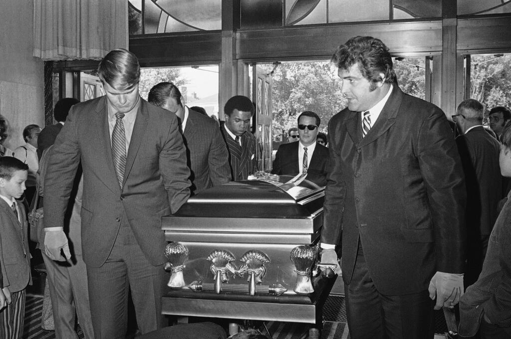 FILE  - In this June 19, 1970, file photo. Chicago Bears teammates of Brian Piccolo carry his coffin into Christ the King Church for funeral services in Chicago. From left, front to back, are Randy Jackson, Dick Butkus and Gale Sayers. Ed O'Bradovich is at right. Hall of Famer Gale Sayers, who made his mark as one of the NFL's best all-purpose running backs and was later celebrated for his enduring friendship with a Chicago Bears teammate with cancer, has died. He was 77. Nicknamed 'The Kansas Comet' and considered among the best open-field runners the game has ever seen, Sayers died Wednesday, Sept. 23, 2020, according to the Pro Football Hall of Fame. (AP Photo/File)