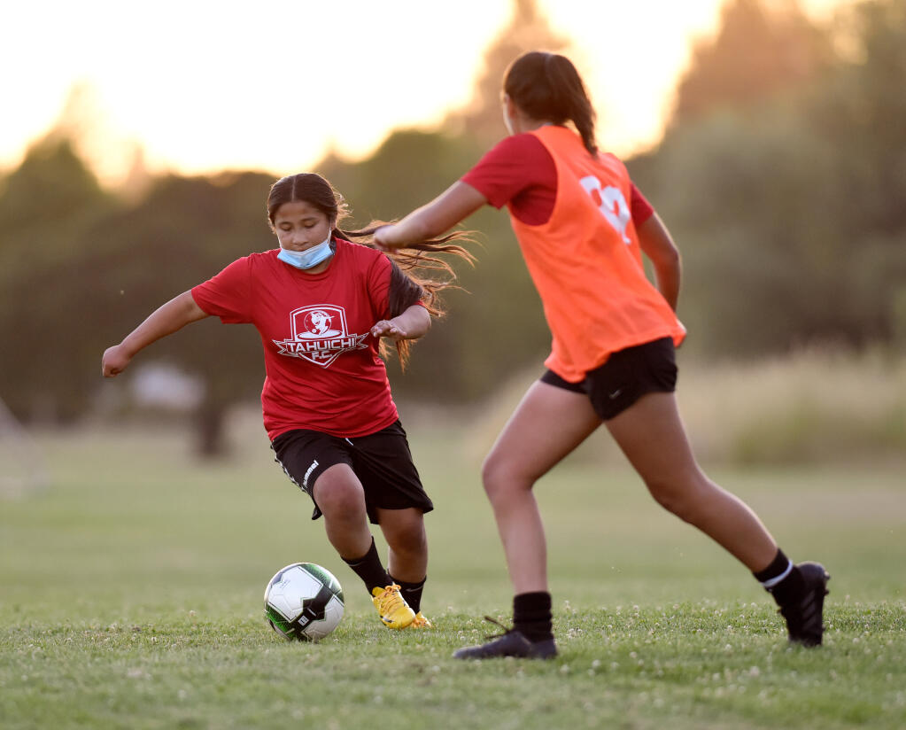 Camila López de Tahuichi FC, a la izquierda, lleva el balón al campo durante una práctica de fútbol en A Place to Play en Santa Rosa, California, el jueves 17 de junio de 2021 (Alvin A.H. Jornada para The Press Democrat).