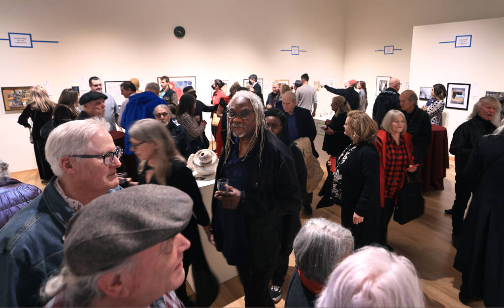 At the 39th annual Art from the Heart benefit auction, people view and silent bid on works of art at University Art Gallery, Saturday, Feb. 4, 2023, on the Sonoma State University campus in Rohnert Park. (Kent Porter/The Press Democrat)