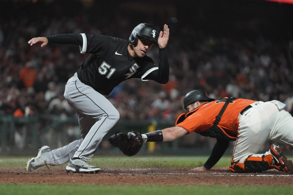The Chicago White Sox’s Adam Haseley scores as Giants catcher Austin Wynns reaches for a tag during the ninth inning in San Francisco on Friday, July 1, 2022. (Eric Risberg / ASSOCIATED PRESS)
