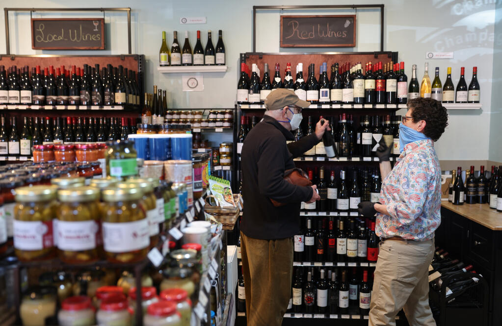 Disco Ranch Wine Bar & Specialty Market owner Wendy Lamer, right, helps Francois Christen select a bottle of wine at her store in Boonville on Thursday, Nov. 11, 2021.  (Christopher Chung/ The Press Democrat)