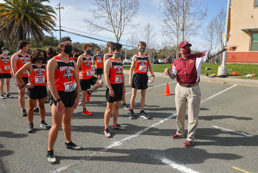 Piner cross-country coach Luis Rosales, right, tells Santa Rosa junior varsity runners that they can lower their masks if they feel comfortable after the first 100 meters of the race in Santa Rosa on Wednesday, March 3, 2021. (Christopher Chung / The Press Democrat)