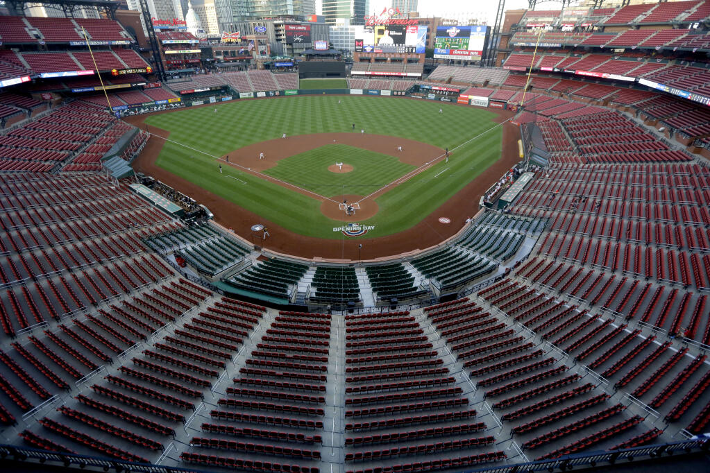FILE - In this July 24, 2020, file photo, empty seats are viewed in Busch Stadium as St. Louis Cardinals starting pitcher Jack Flaherty throws in the first inning baseball game against the Pittsburgh Pirates in St. Louis. Major League Baseball players rejected a proposal to delay the start of spring training and the season due to the coronavirus pandemic, vowing Monday, Feb. 1, 2021, to report under the original schedule. (AP Photo/Jeff Roberson, File)