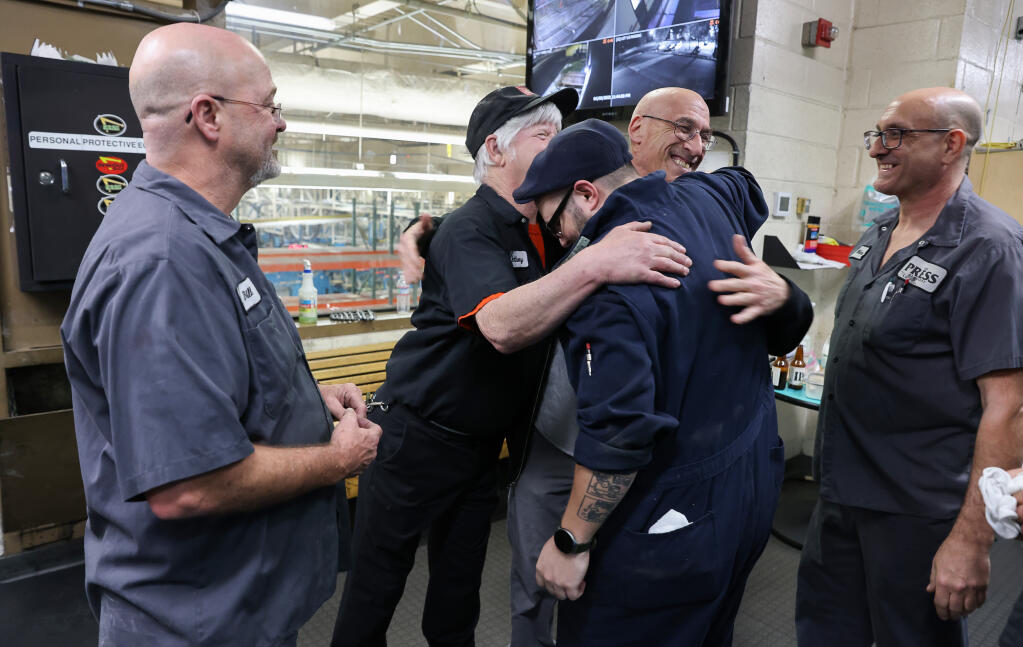 Pressmen Bill Fuiten, left, Anthony Munger, Sam Robinson, Jay Hornstein, and Mike Johnston embrace after the final print run of The Press Democrat is completed at the printing facility in Rohnert Park on Sunday, April 3, 2022.  The newspaper will now be printed in Fremont.  (Christopher Chung/ The Press Democrat)