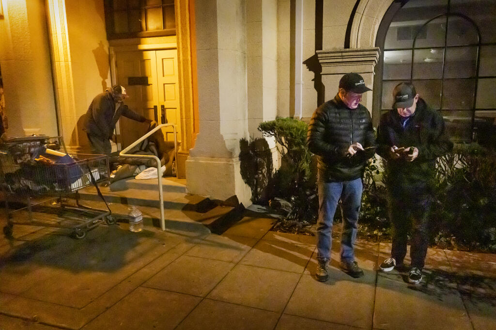 Former mayor Tom Schwedhelm and Santa Rosa police captain John Cregan use a phone app to record homeless numbers, ages and sex on their sweep of the St. Rose historic district in Santa Rosa at 5:30 a.m. during the annual homeless count early Friday morning, February 25, 2022.  (Photo by John Burgess/The Press Democrat)