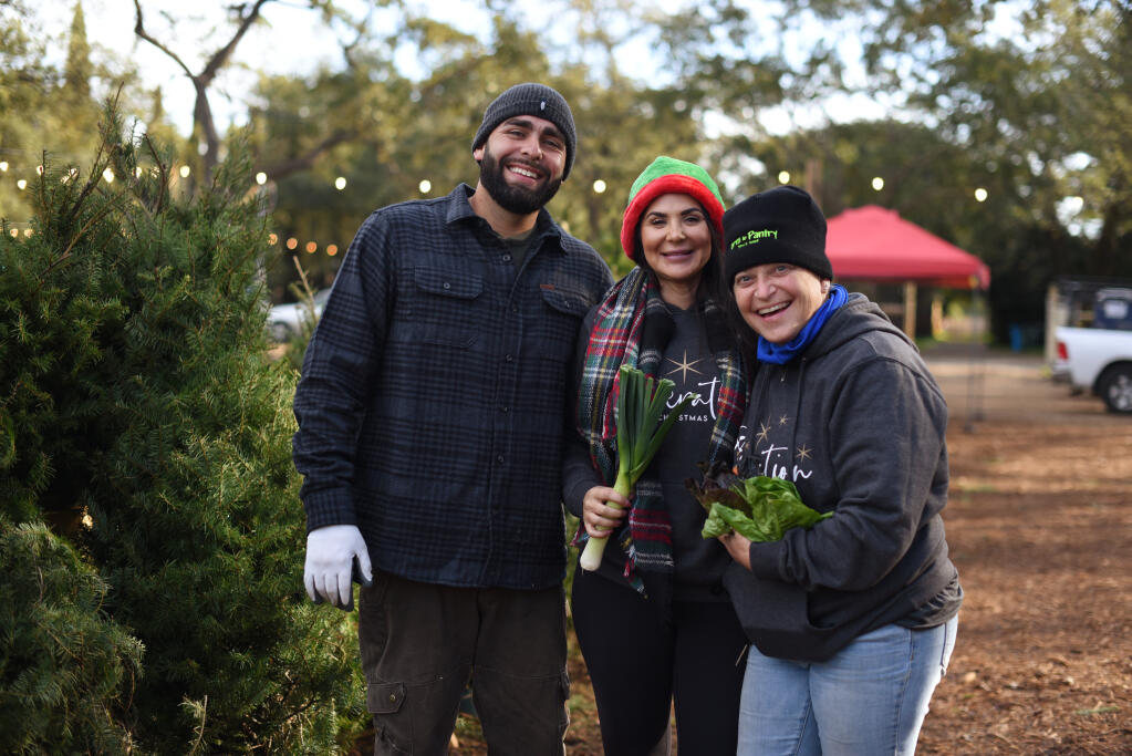 From left, the founders of Operation Christmas tree Jess Crowder and Tory Crowder with Duskie Estes who donated 400 CSA boxes from her nonprofit Farm to Pantry during a Christmas tree give away for families in need at Haystack Farm in Sonoma, Saturday, Dec. 11, 2021. (Erik Castro / For The Press Democrat file)